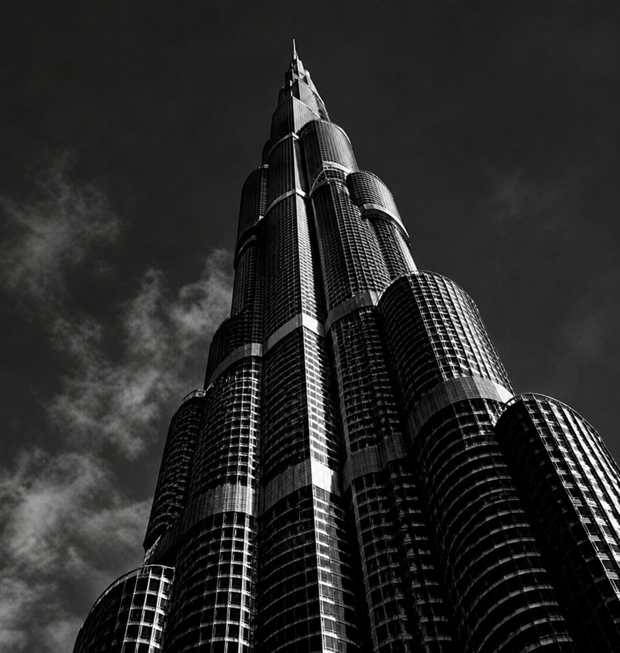 A Dubai tower rising beneath storm clouds